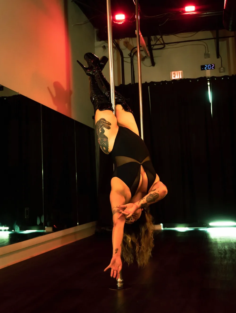 A dancer training on the pole in the Pole Body & Arts studio